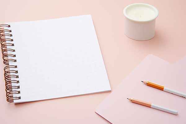 Jegyzetfüzet és toll egy asztalon, nyugodt fényben